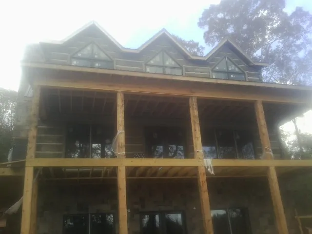 Dormers and porch framing on a large log home under construction — Roof Coating work by our crew in Walterville
