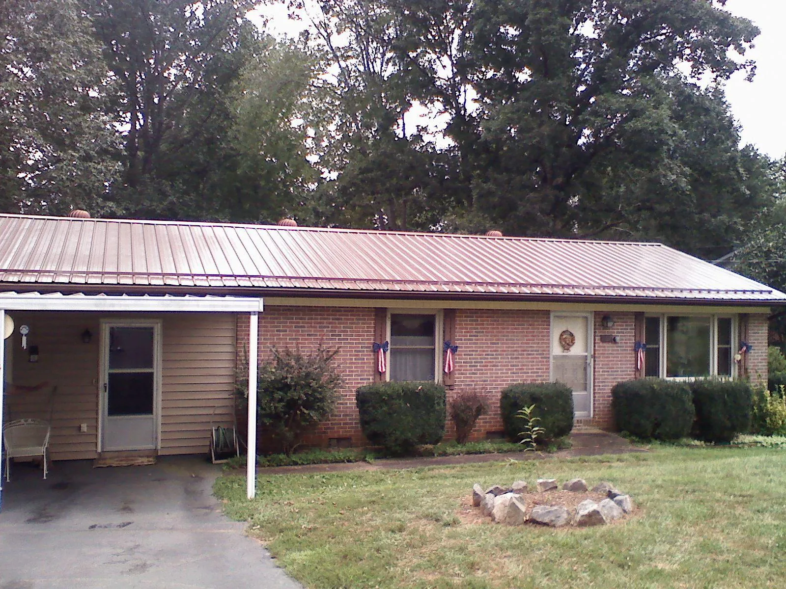 Bronze metal roof and carport on a brick ranch home — Roof Repair work by our crew in Walterville